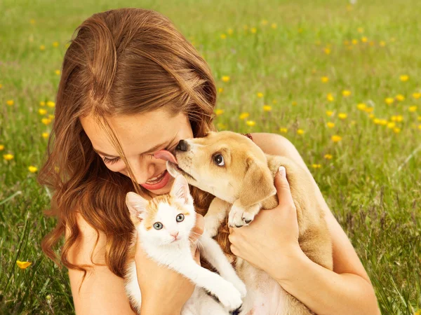 年轻的女孩，抱着小猫和小狗 — 图库照片
