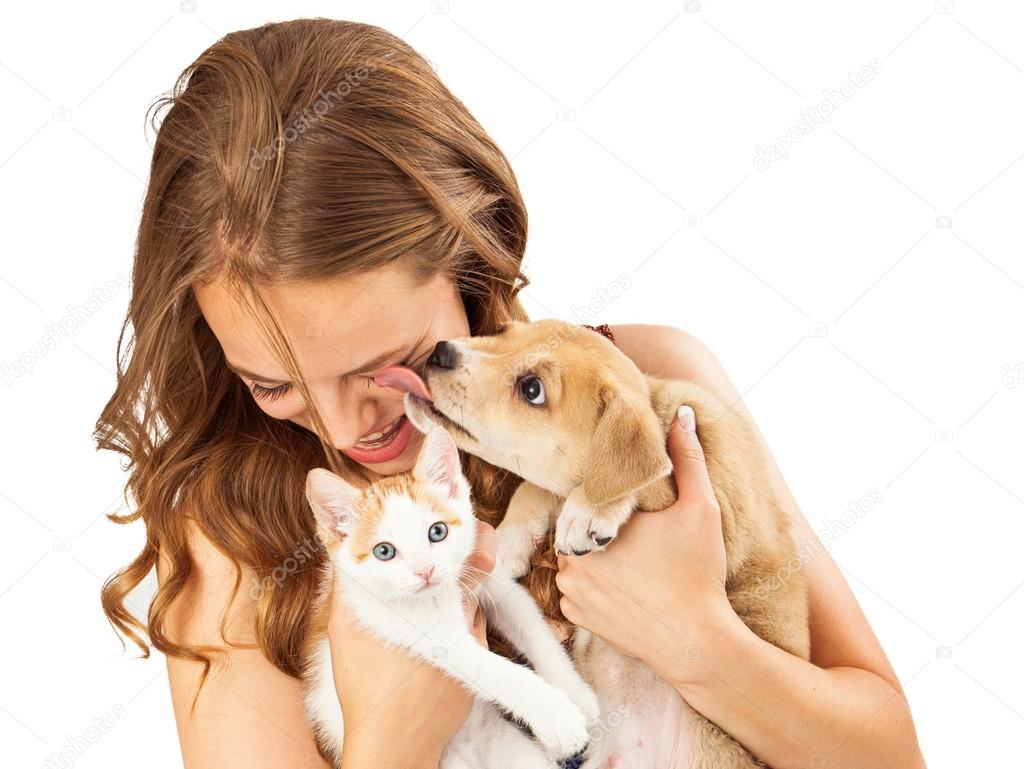 young girl holding kitten and puppy