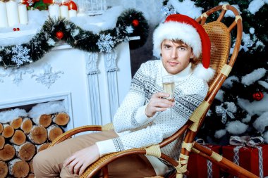 christmas. Happy young man with a glass of champagne. clipart