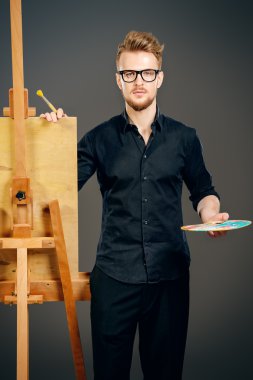 yaratıcılık. Erkek sanatçı boya atölye bir şövale üzerinde.