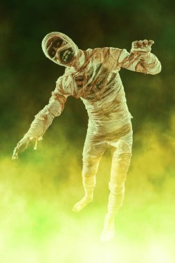 Yanan gözlü şeytani mumya, sarı dumanla karanlık arka planda korkutur. Cadılar Bayramı. Antik Mısır mitolojisi.