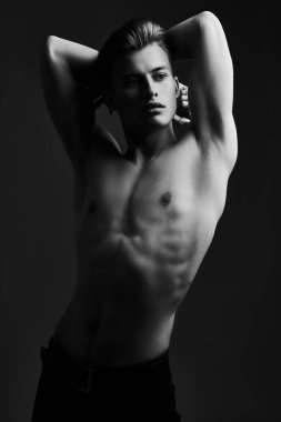Mükemmel kaslı vücudu olan yakışıklı bir genç adamın siyah-beyaz portresi. Spor ve vücut geliştirme. Erkeklerin güzelliği ve sağlığı.