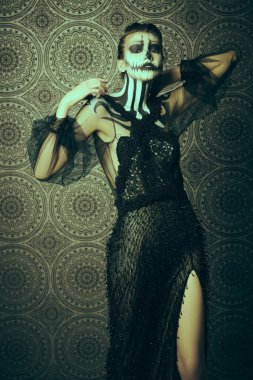 Güzel ve korkunç balkabağı kraliçesi. Kaliteli arka planda kafatası kabağı makyajlı manken. Cadılar Bayramı konsepti.