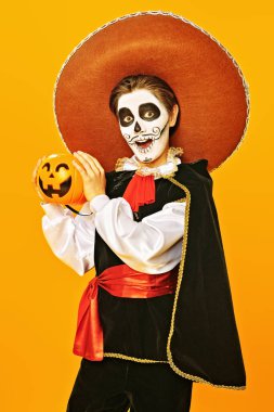 Parlak sarı arka planda şeker mi şaka mı makyajlı duygusal çocuk. Cadılar Bayramı. Dia de los muertos. Ölüler günü. Boşluğu kopyala.