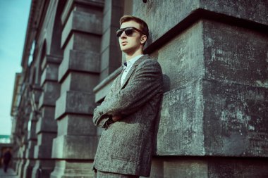 Zarif takım elbiseli modern genç işadamı bir şehir caddesinde poz veriyor. Erkek modası. İş biçimi. 