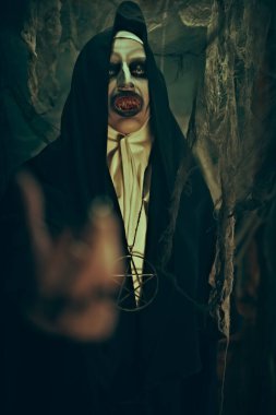 Cadılar Bayramı. Karanlık terk edilmiş odada örümcek ağlarıyla elini uzatan lanetli bir rahibenin portresi. Dehşet.