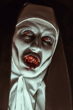 Kameraya bakan kanlı dişli şeytani korkunç bir rahibenin yakın plan portresi. Cadılar Bayramı ve Dehşet.