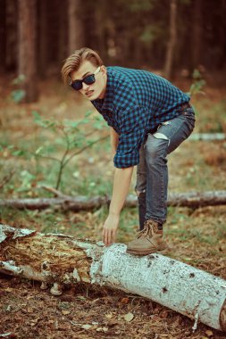 Vahşi ormanda yakışıklı, erkeksi bir adam. Macera, özgürlük ruhu. Etkin yaşam biçimi. 