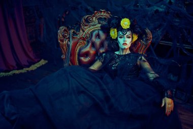 Kafatası şekeri kız. Ölüler Günü. Dia de los muertos. Çekici ve tehlikeli Calavera Catrina koltukta oturuyor. Cadılar Bayramı.