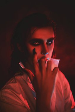 Kırmızı ışıkta kana susamış korkunç bir vampirin portresi. Cadılar Bayramı.