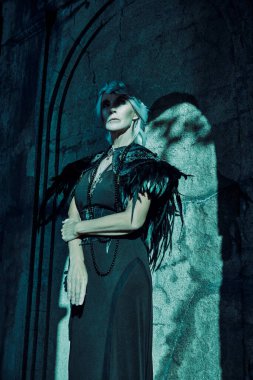 Güzel gri saçlı ve zengin siyah elbiseli aristokrat bir dul kadın mezarlıktaki bir mahzende üzgün duruyor. Kara Dul. Gizemciliğin atmosferi. Cadılar Bayramı.