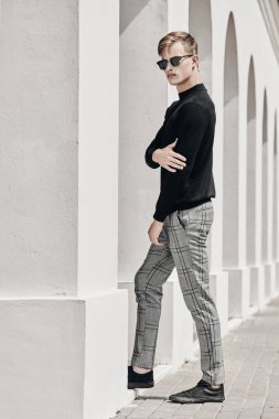 Şehir güvertesinde yürüyen yakışıklı genç adam. Yaz modası. Yaz tatili ve tatil.