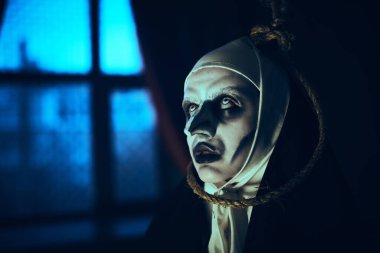 Korkunç lanetli bir rahibenin portresi. Terk edilmiş kilisede boynunda asılı duran bir halkayla duruyor. Dehşet. Cadılar Bayramı.