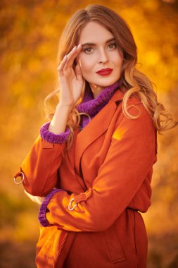 Sonbahar arka planında gülümseyen güzel bir genç kadının portresi. Sonbahar güzelliği, moda.