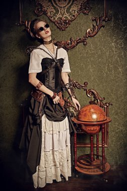 Victoria döneminden kalma iç mimarisi olan bir odada duran güzel bir steampunk bayanın tam boy portresi. Steampunk dünyası. 