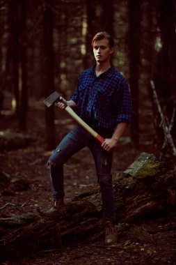 Vahşi ormanda baltası olan yakışıklı, güçlü bir oduncunun tam boy portresi.. 