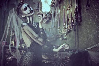 Eski kale dekorasyonlarında kafatası kabağı makyajı yapan zarif bir bayan. Eski tarz. Cadılar Bayramı. Ölülerin Günü. 