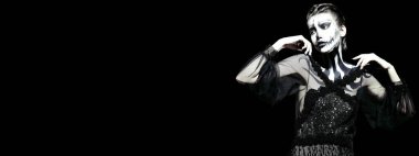 Siyah arka planda balkabağı kafatası makyajı olan zarif bir kadın. Cadılar Bayramı. Ölüler Günü. Boşluğu kopyala.