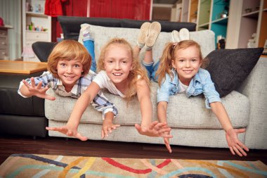 Aile kavramı. Mutlu çocuklar evdeki bir oturma odasında birlikte oynuyorlar. Mutlu çocukluk.