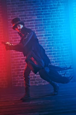 Duvarda bir silahla koşan cesur bir erkek savaşçının tam boy portresi. Steampunk dünyası. 