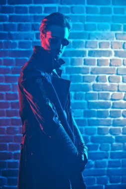 Steampunk konsepti. Duvarda güneş gözlüğü ve ceket giyen yakışıklı bir steampunk 'ın portresi..