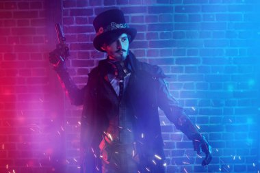 Sisli bir sokakta silahlı cesur bir erkek savaşçının tam boy portresi. Steampunk dünyası. 