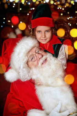 Nazik yaşlı Noel Baba ve evdeki küçük elf kızının portresi. Noel ve Yeni Yıl masalları.
