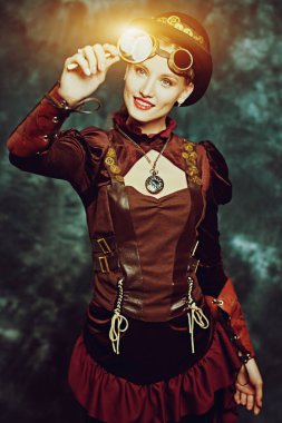 Steampunk konsepti. Arkaplanda büyüteçle bakan güzel bir steampunk kızının portresi. Boşluğu kopyala.