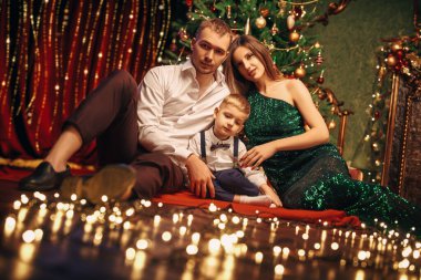 Neşeli ebeveynler sevgili oğullarıyla birlikte güzel, rahat bir Noel atmosferinde otururlar. Mutlu aile tatilleri.. 