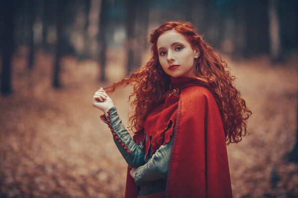 По лесу гуляет красивая рыжая девушка средневековья. Кельтская культура. Мир фантазий.