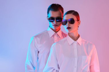 Beyaz gömlekli ve modern güneş gözlüklü bir mankenin portresi. Gözlük modası. Stüdyo çekimi.