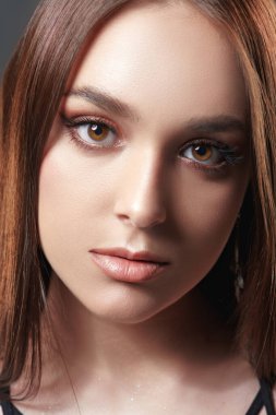 Makyaj ve makyaj malzemeleri. Kahverengi makyajlı güzel bir esmer kızın yakın plan portresi..