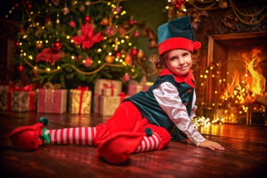 Şirin gülümseyen elf kız Noel Baba 'ya yardım etmeye hazır. Noel Baba 'nın Evi.