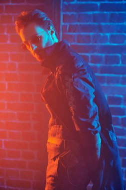 Steampunk konsepti. Duvarda güneş gözlüğü ve ceket giyen yakışıklı bir steampunk 'ın portresi..