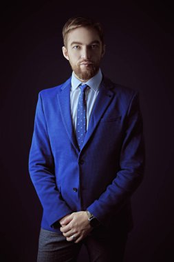 Siyah arka planda, klasik takım elbiseli, orta yaşlı yakışıklı bir adamın portresi. İş adamı portresi. Erkek modası.