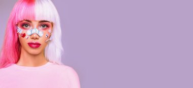 Anime tarzı. Pembe beyaz saçlı, parlak pembe makyajlı, yapıştırmalı ve yüzünde dekoratif yapıştırıcı olan modern bir genç kız. Boşluğu kopyala. 