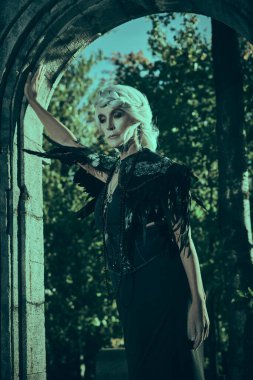 Kara Dul. Güzel gri saçlı ve zengin siyah elbiseli aristokrat bir dul kadın kalenin kemerinde üzgün duruyor. Fantezi Dünyası. Cadılar Bayramı.