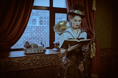 Güzel steampunk kadın bilim adamı laboratuarında duruyor ve bir kitap okuyor. Viktorya döneminden kalma iç mimari. 