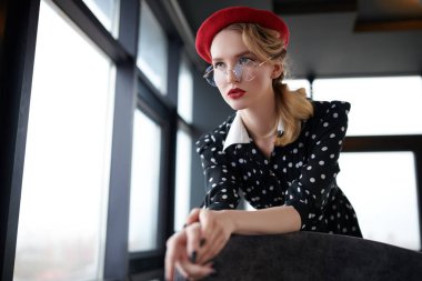 Makyajlı ve pim tarzında giyinmiş zarif bir genç kadının portresi. Güzellik, moda. Optik ve gözlük.