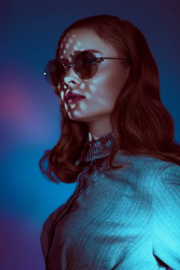 Modern yuvarlak güneş gözlüklü, zarif, genç bir kadının portresi. Gözlük modası. 