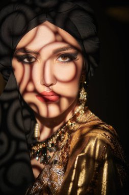 Doğulu peri masalı. Geleneksel makyaj ve siyah tesettüre sahip güzel bir Arap kadının portresi. Makyaj ve kozmetik. 