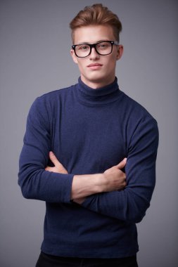 Sarı saçlı, gözlüklü ve kameraya gülümseyen yakışıklı bir gencin portresi. Erkekler için optik.