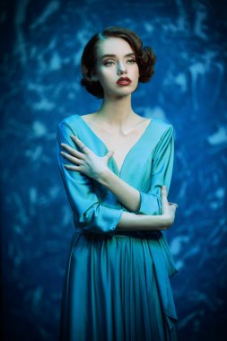 Zarif elbiseli güzel melankolik kız grunge arka planda duruyor. Saç ve makyaj 20 'li yılların tarzında.. 