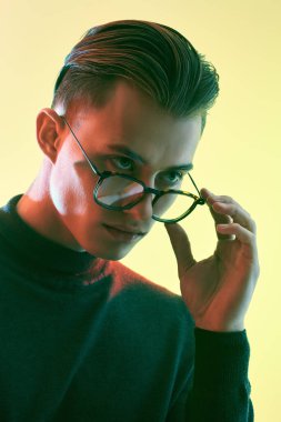 Erkek aksesuarları, optikler. Zarif gözlüklü yakışıklı bir gencin portresi. İş biçimi.