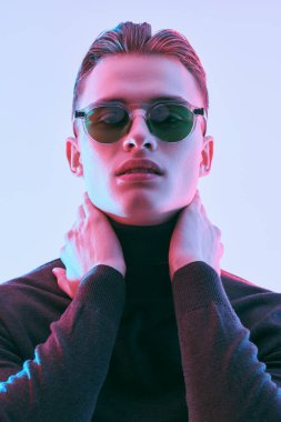 Erkek aksesuarları, optikler. Modern güneş gözlüklü yakışıklı genç adam. Stüdyo resmi. 