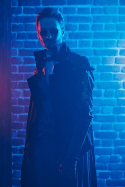 Steampunk dünyası. Duvarda koyu mavi ışık altında cesur bir dieselpunk 'ın portresi..