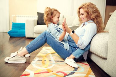 Evde mutlu bir aile hayatı. Bir anne, sevimli kızıyla oturma odasında oynayarak vakit geçirir..