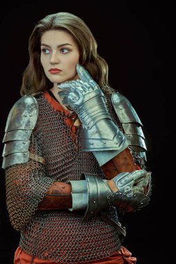 Beautiful medieval woman warrior in chain mail and plate armor on a black background. clipart