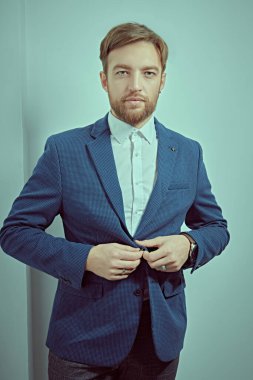 Klasik takım elbiseli, yakışıklı, orta yaşlı bir adamın, ciddi ciddi kameraya bakan portresi. İş adamı portresi. Erkek modası.