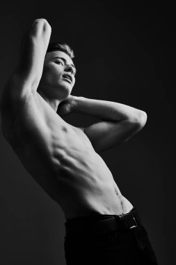 Mükemmel kaslı vücudu olan yakışıklı bir genç adamın siyah-beyaz portresi. Spor ve vücut geliştirme. Erkeklerin güzelliği ve sağlığı.